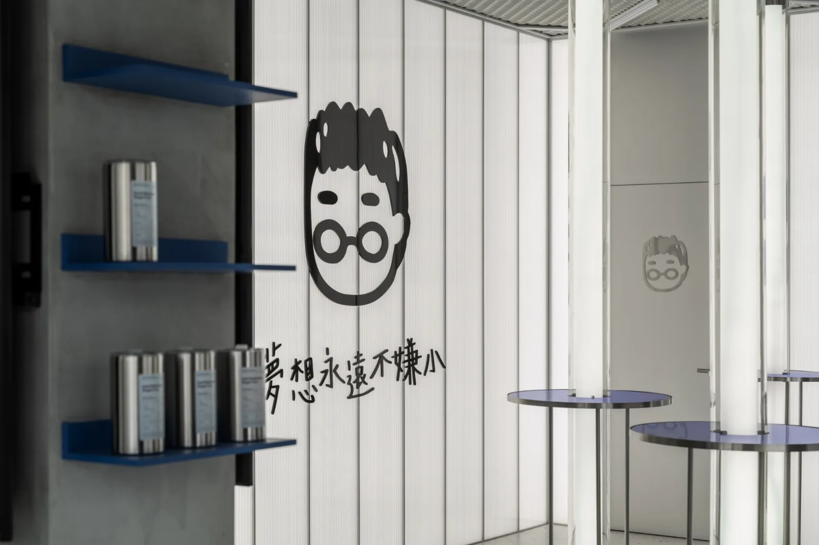 旗艦店室內：不鏽鋼圓弧、光柱吧檯與 3C 展示